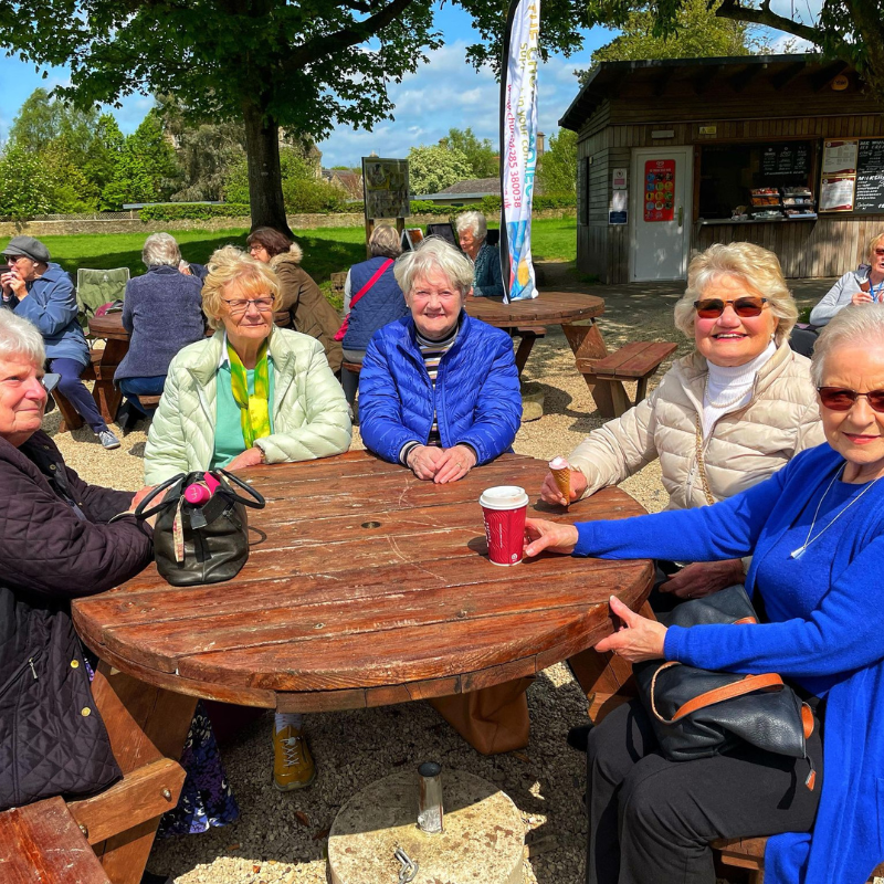 A group of Friendship Café participants sat out in the sunshine in St Michael's Park