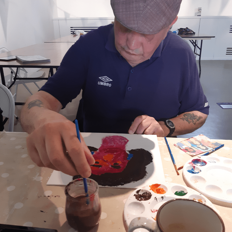 Stitch, Knit & Natter Participant sat at the table painting