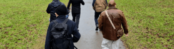 A group of people walking in Cirencester Park with Buster, the Jack Russell.