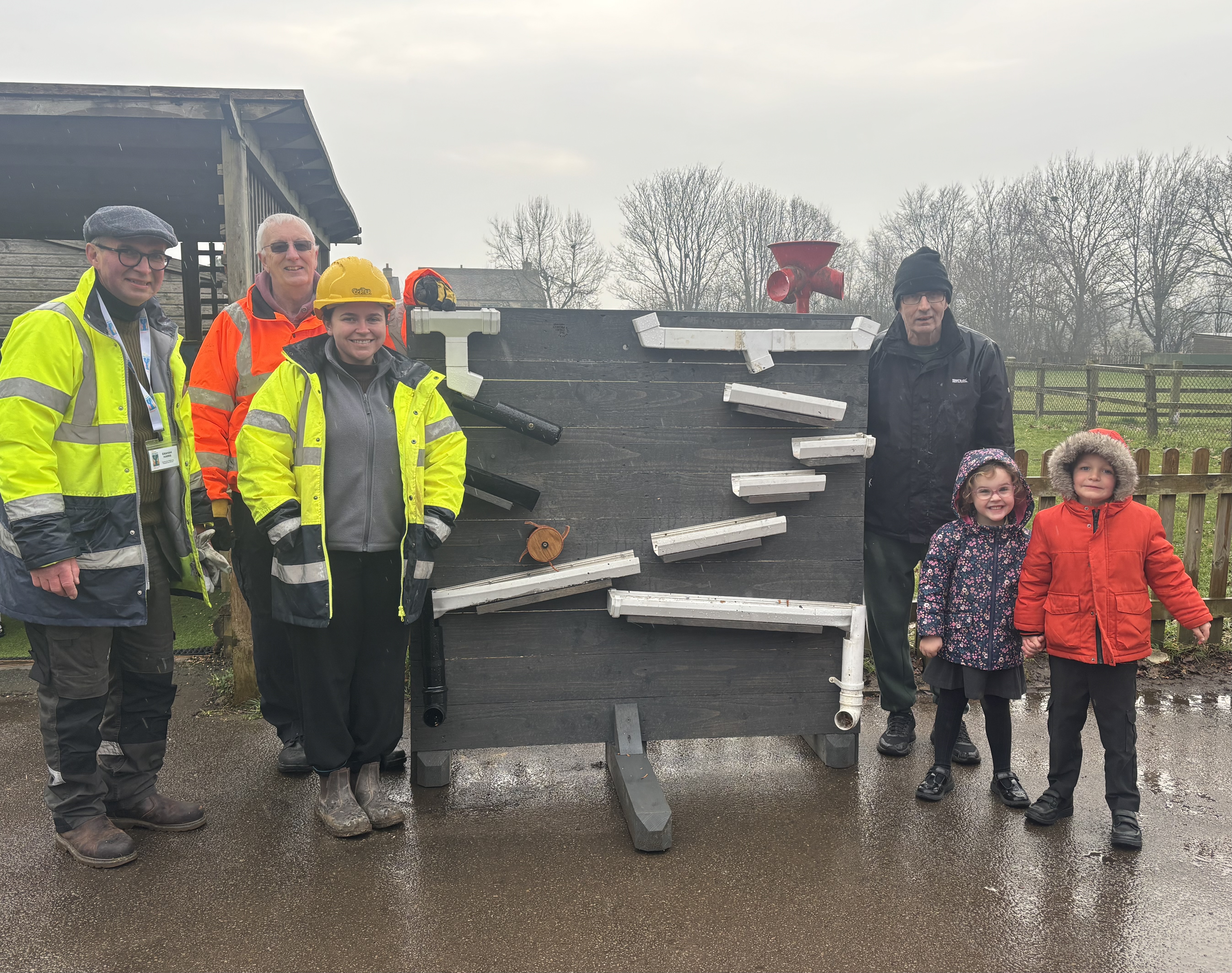 Men's Shed volunteers with Ann Edward's Primary School pupils receiving waterboard